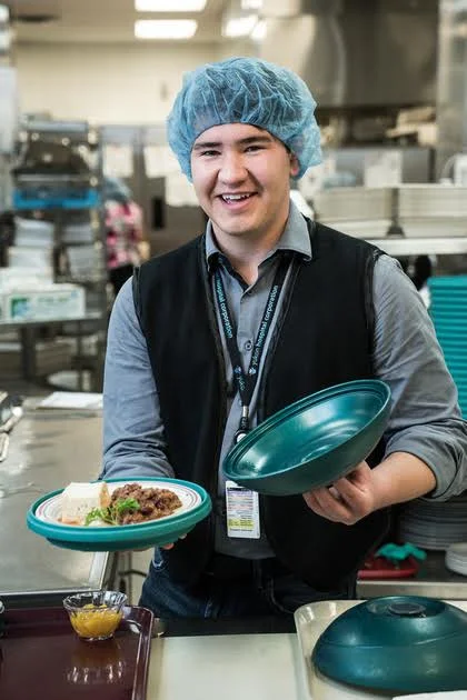 Connor, a staff member showing off traditional food served at Yukon Hospital.