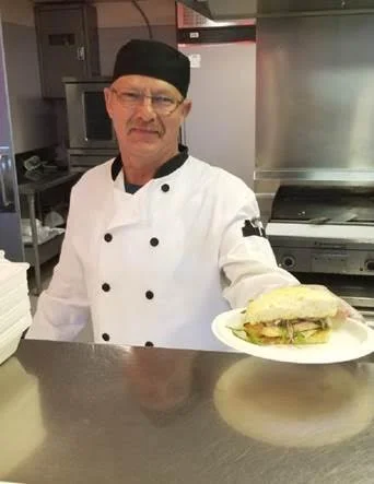 Paul Neiman, a cook at the Wascana Rehabilitation Centre (Regina) , proudly displays the salmon on bannock sandwich prepared in honour of National Indigenous Peoples Day. Wascana joined the Pasqua Hospital, the Regina General Hospital and Regina Pioneer Village in this celebration, serving more than 2000 servings of bison stew and salmon sandwiches to our patients, staff, and visitors.
