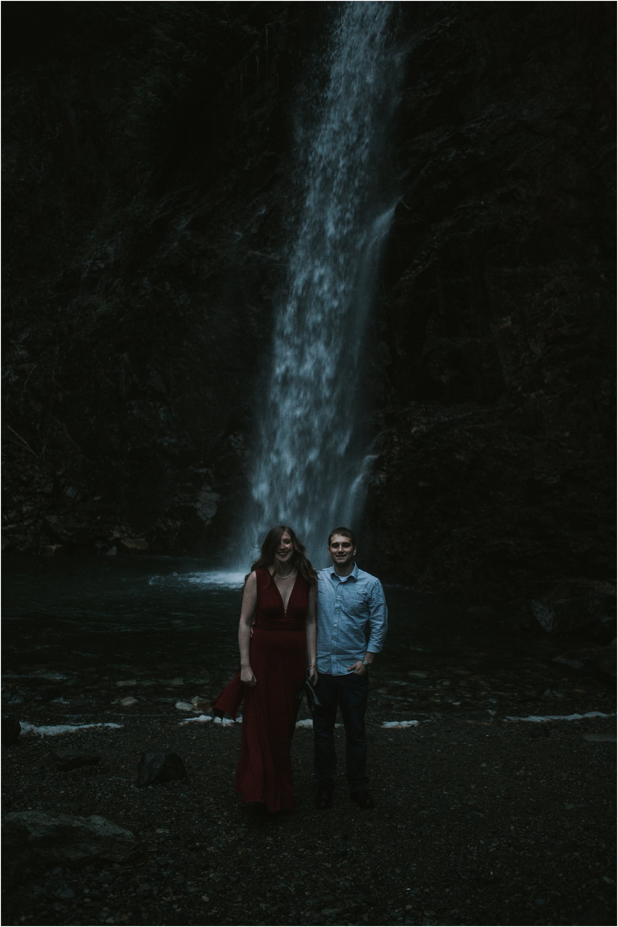 engagement couple standing in front of waterfall