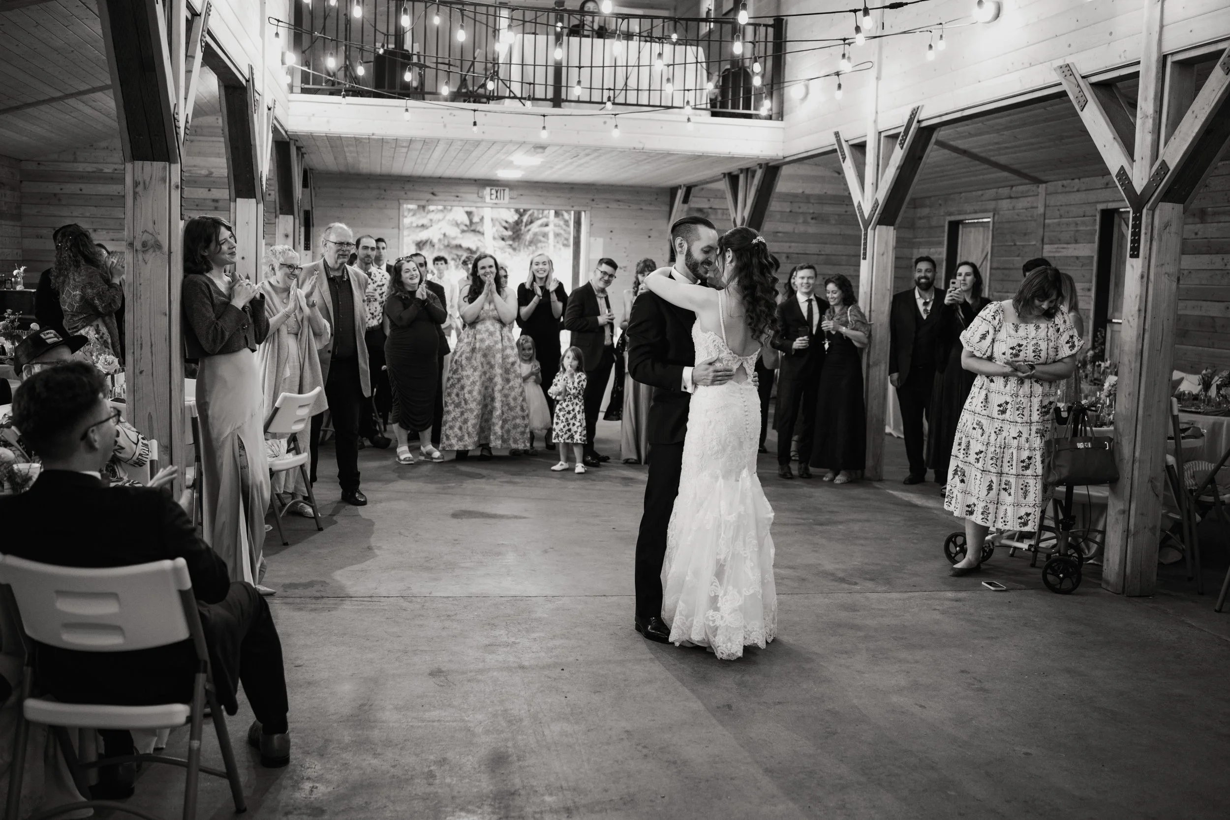 a bride and groom share their first dance while a crowd looks on