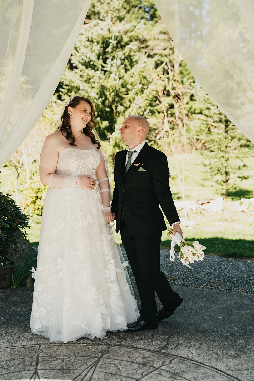 a wedding couple stands at the altar and looks at each other