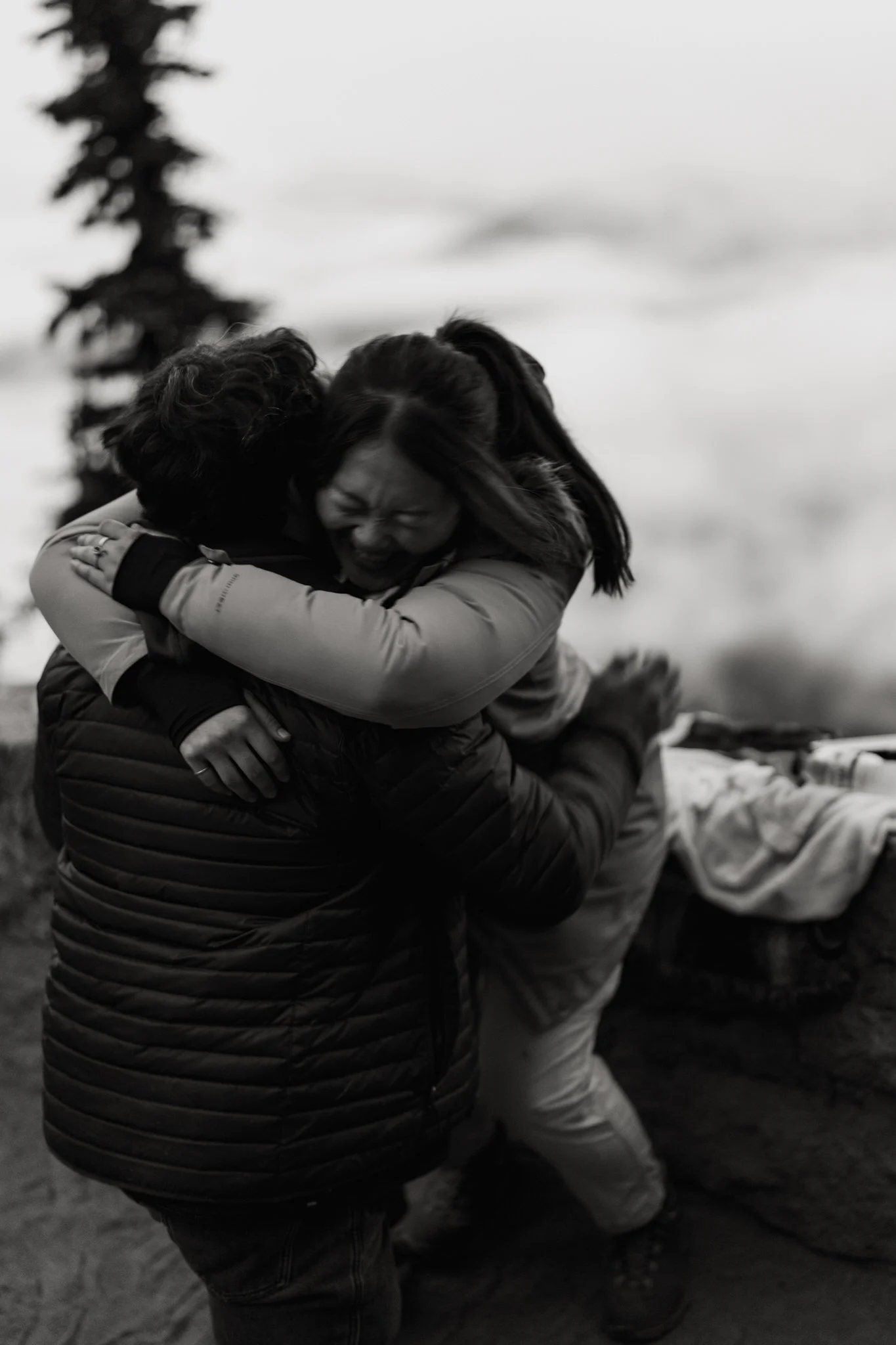 a woman throws herself at a man after he asked her to marry him at Mount Rainier National Park