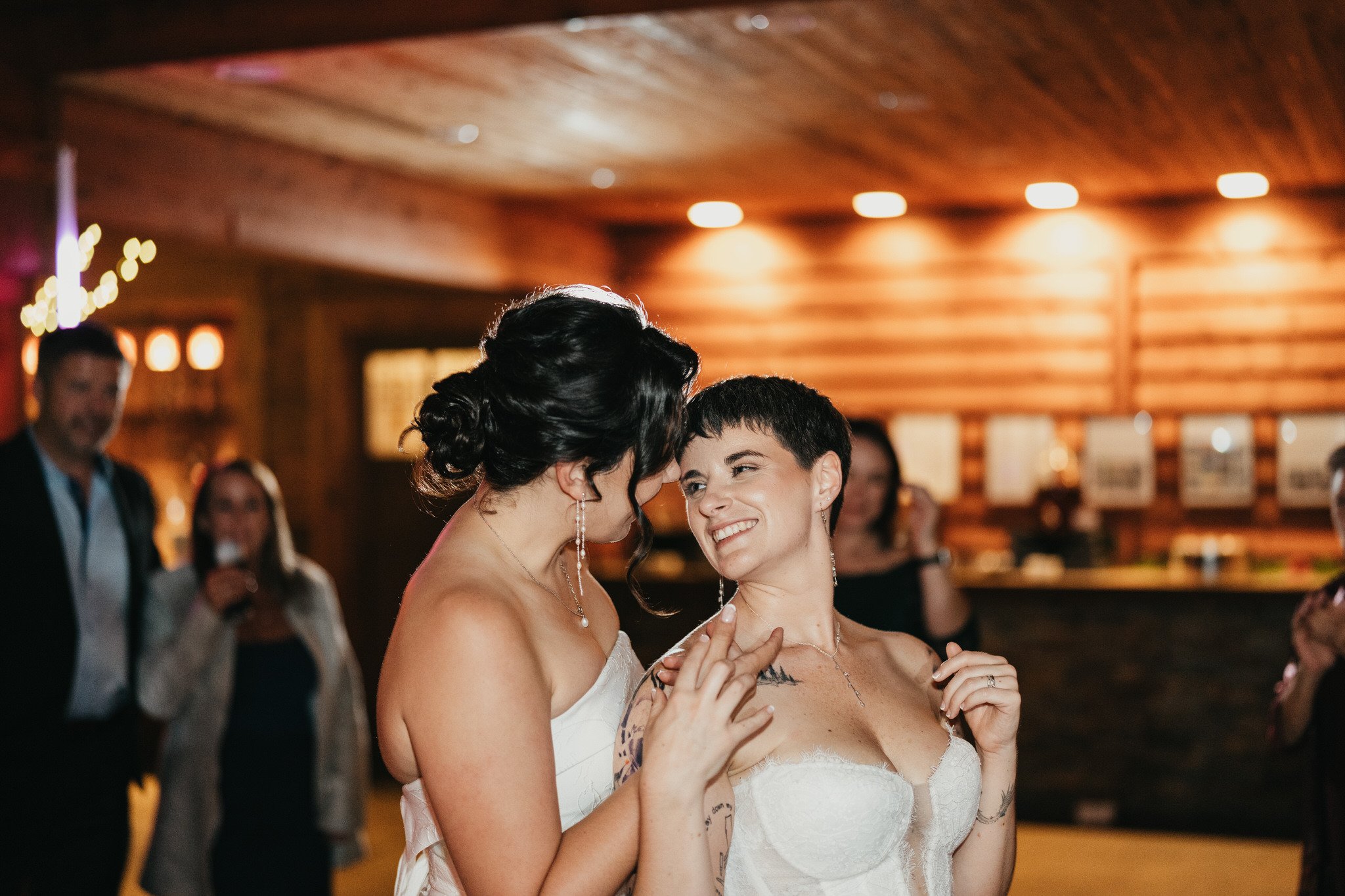 two brides look at each other while dancing on their wedding night