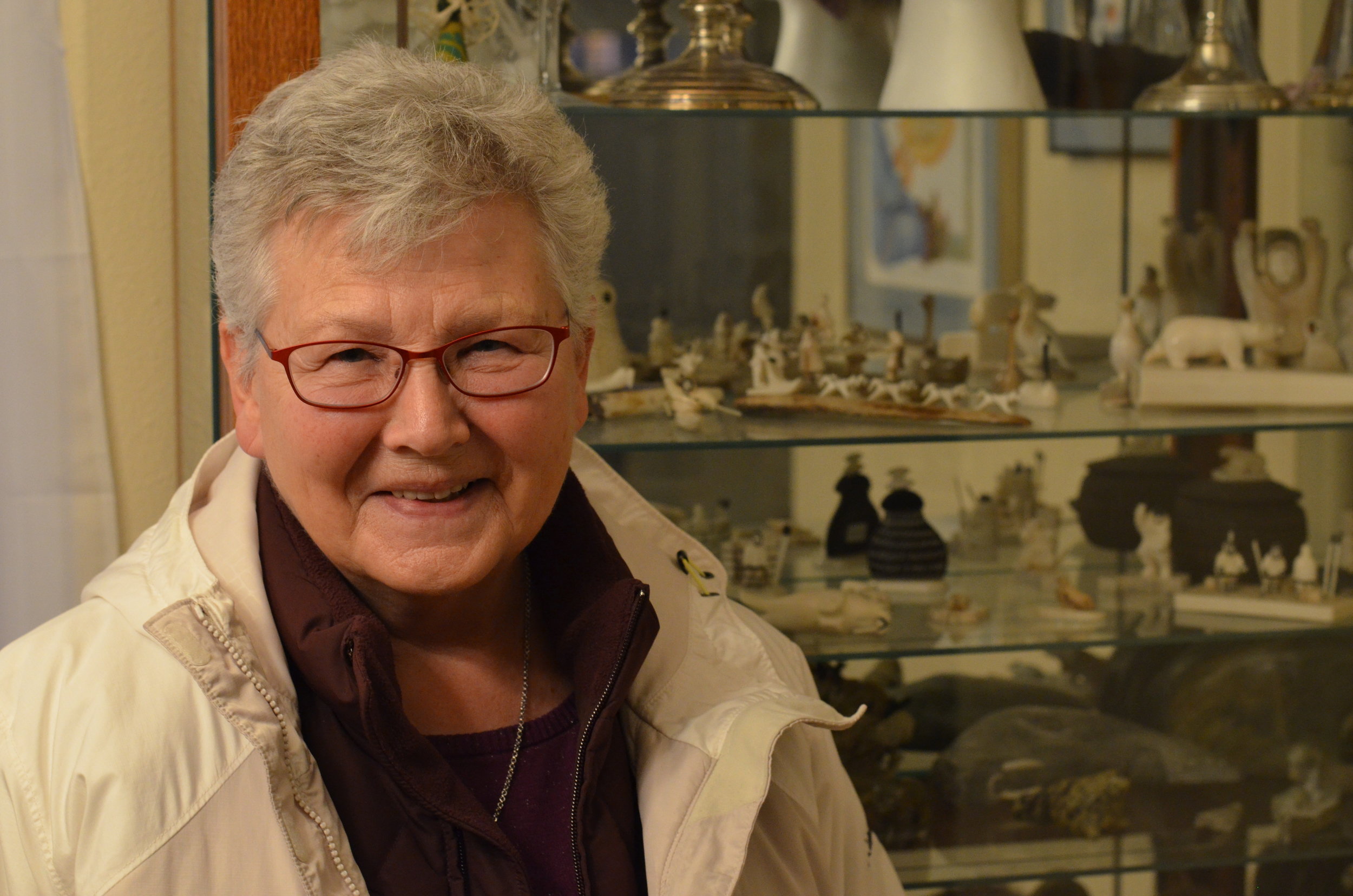 Johnson at the home of her friend Florence Francis Busch, standing before a case of ivory and bone carvings.