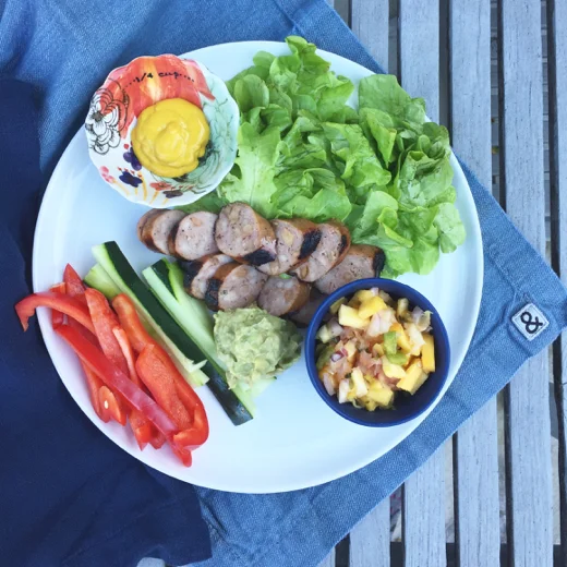 Chicken apple sausage with mustard, greens, mango salsa, red pepper and cucumber to dip into avocado crema.