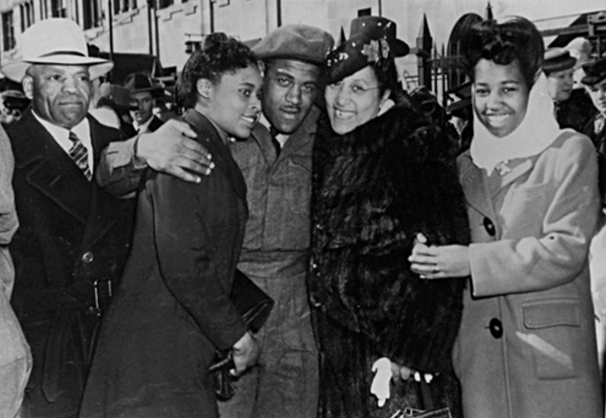 Corporal Theodore 'Ted' King met by his parents on his return to Calgary, Alberta. L-R: John King, Della Mayes (later married Ted King), Stella King, Violet King - Glenbow Archives, na-4987-5