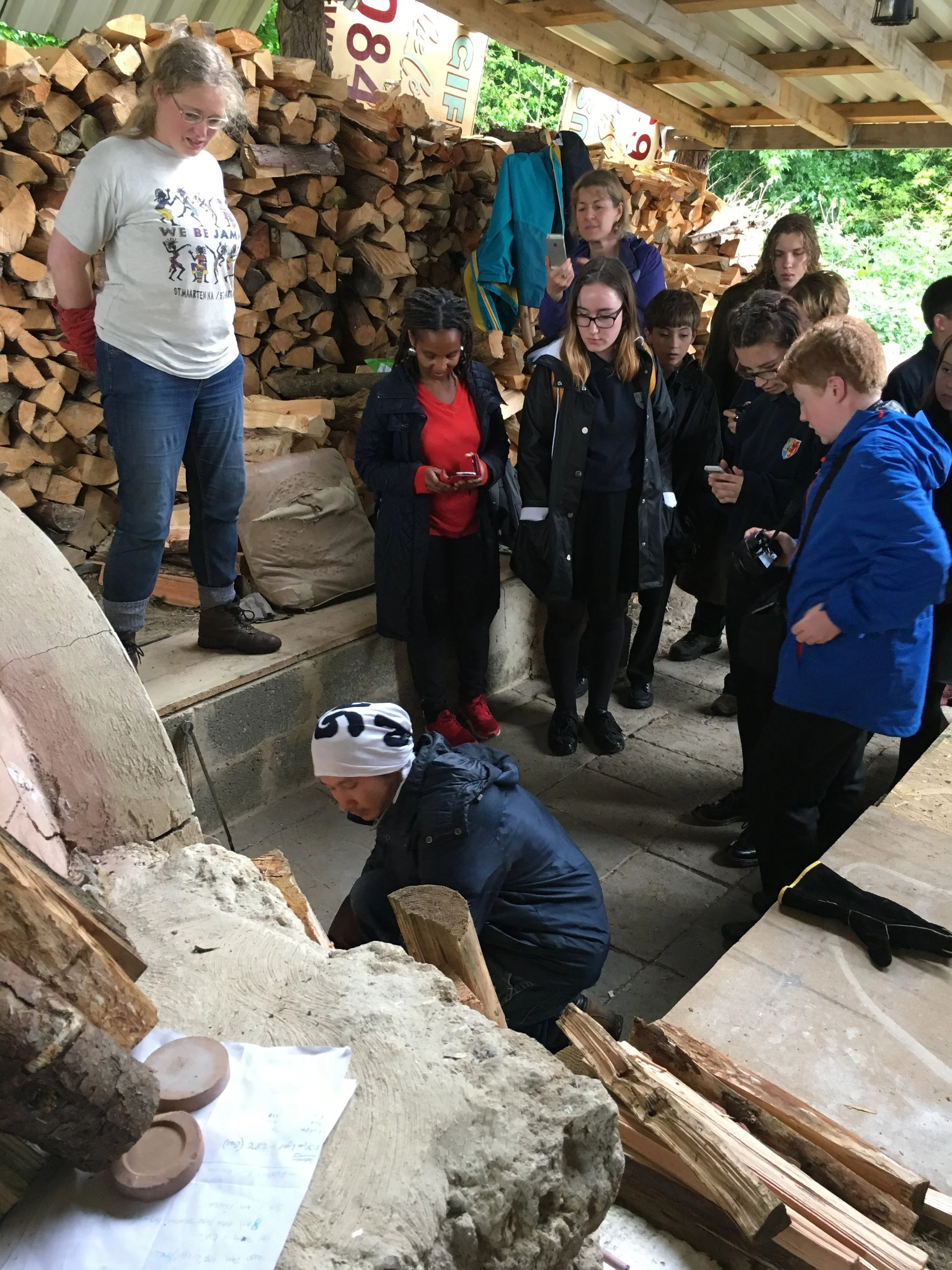 Local school pupils watch Kazuya san stoke the kiln.