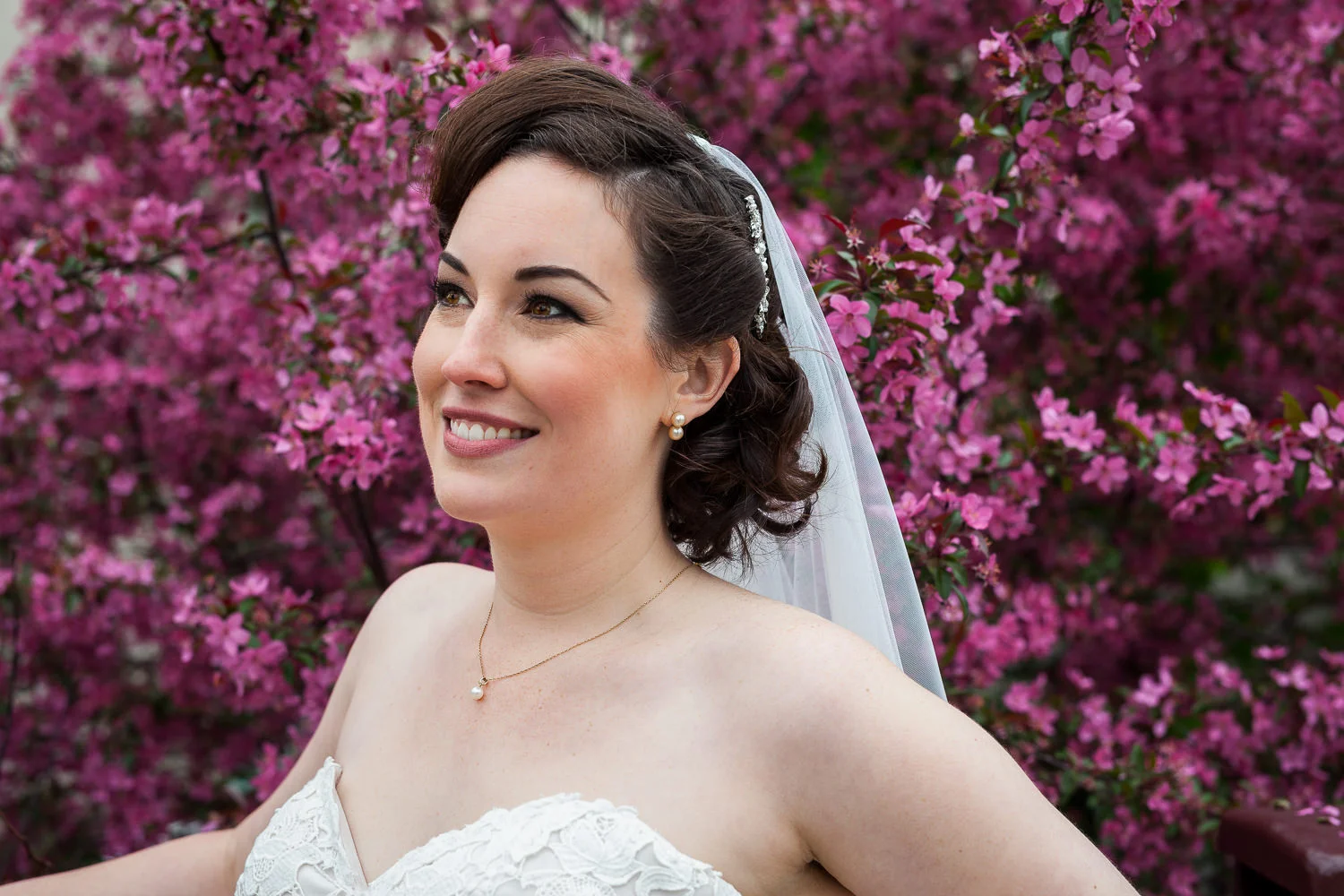 bride poses in front of a spring flowering tree near the Kinzie bridge in Chicago
