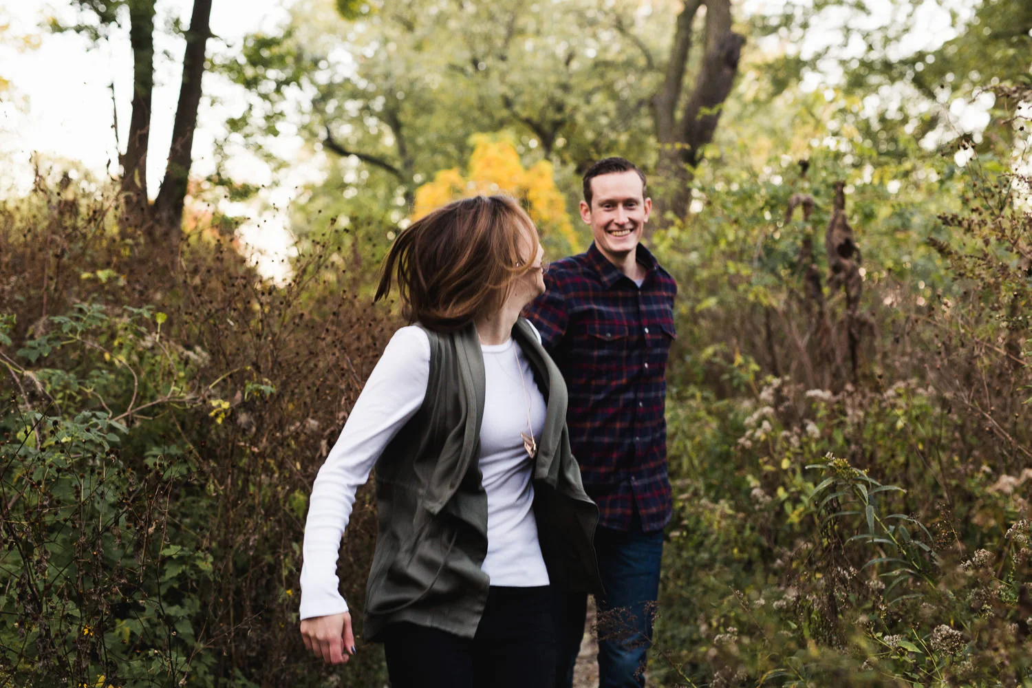 engaged couple running at montrose harbor in chicago