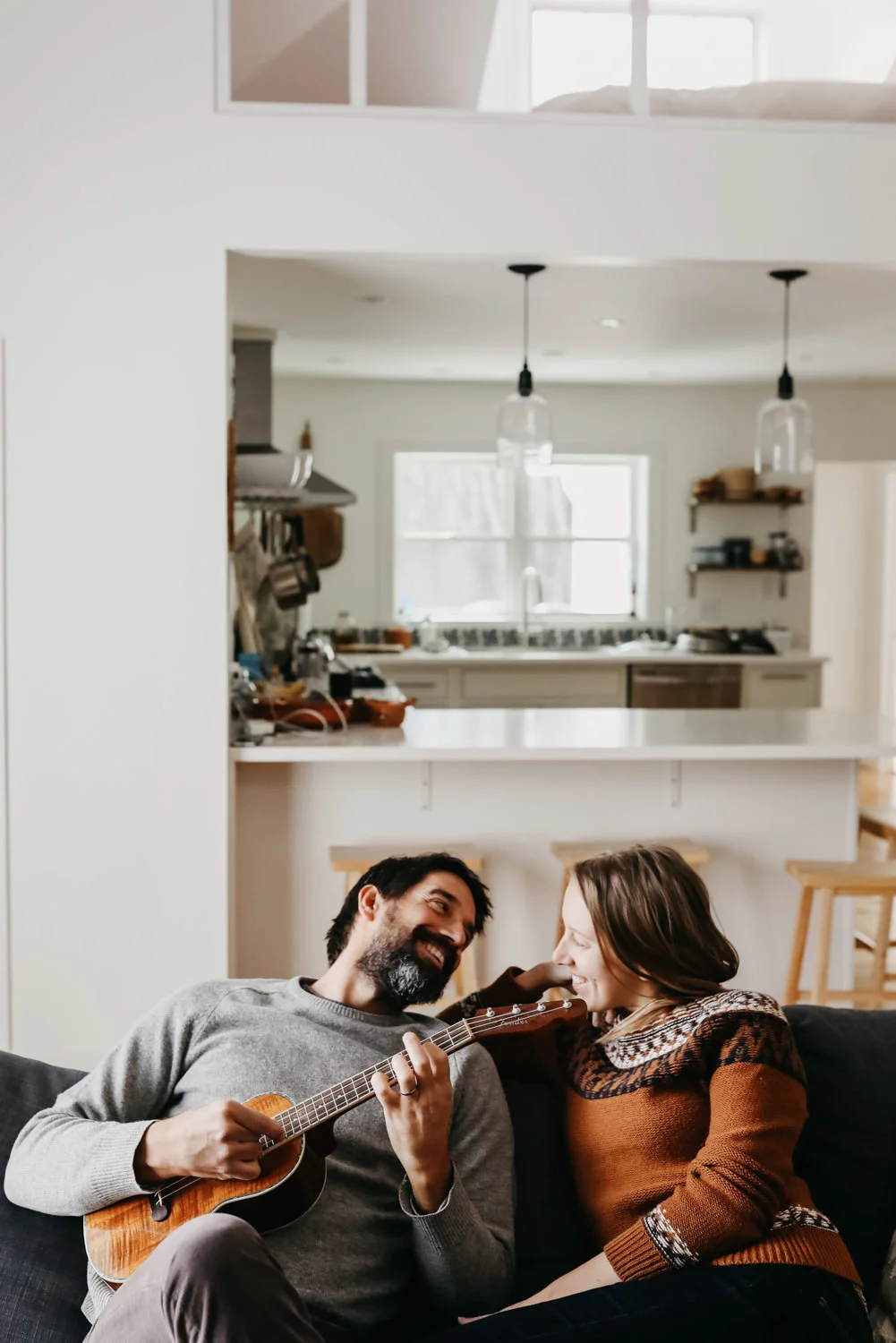 Michigan couple sitting on their couch and playing ukulele