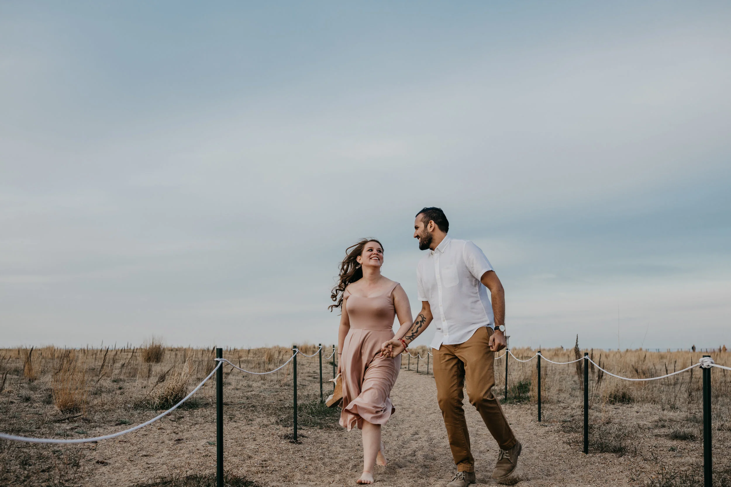 engaged couple running at Loyola Beach in Chicago