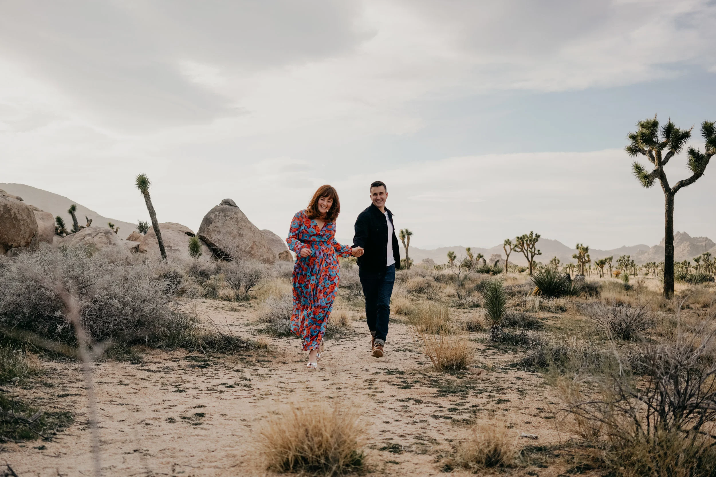 engaged couple running in Joshua Tree