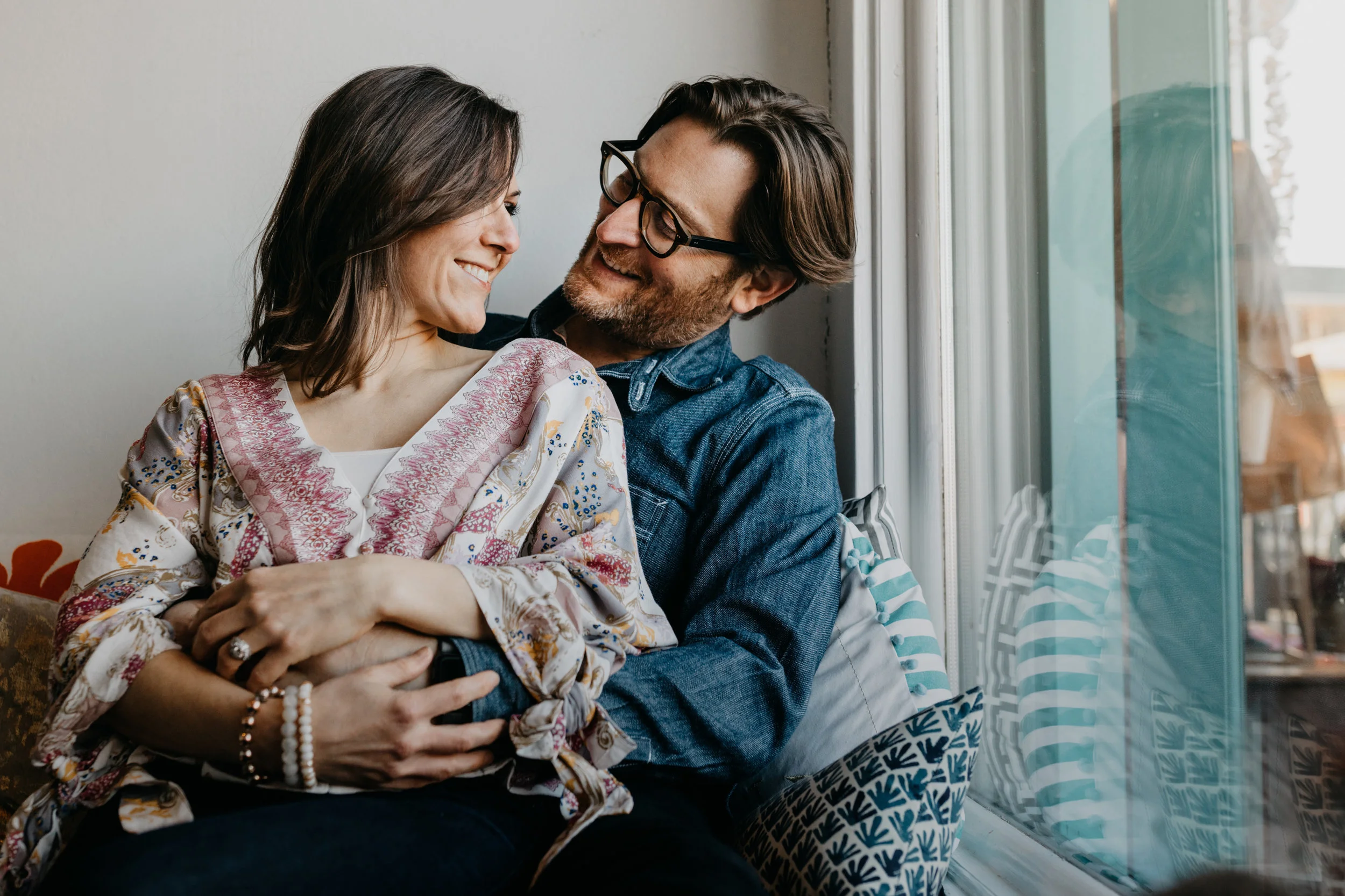 engaged couple sitting near window