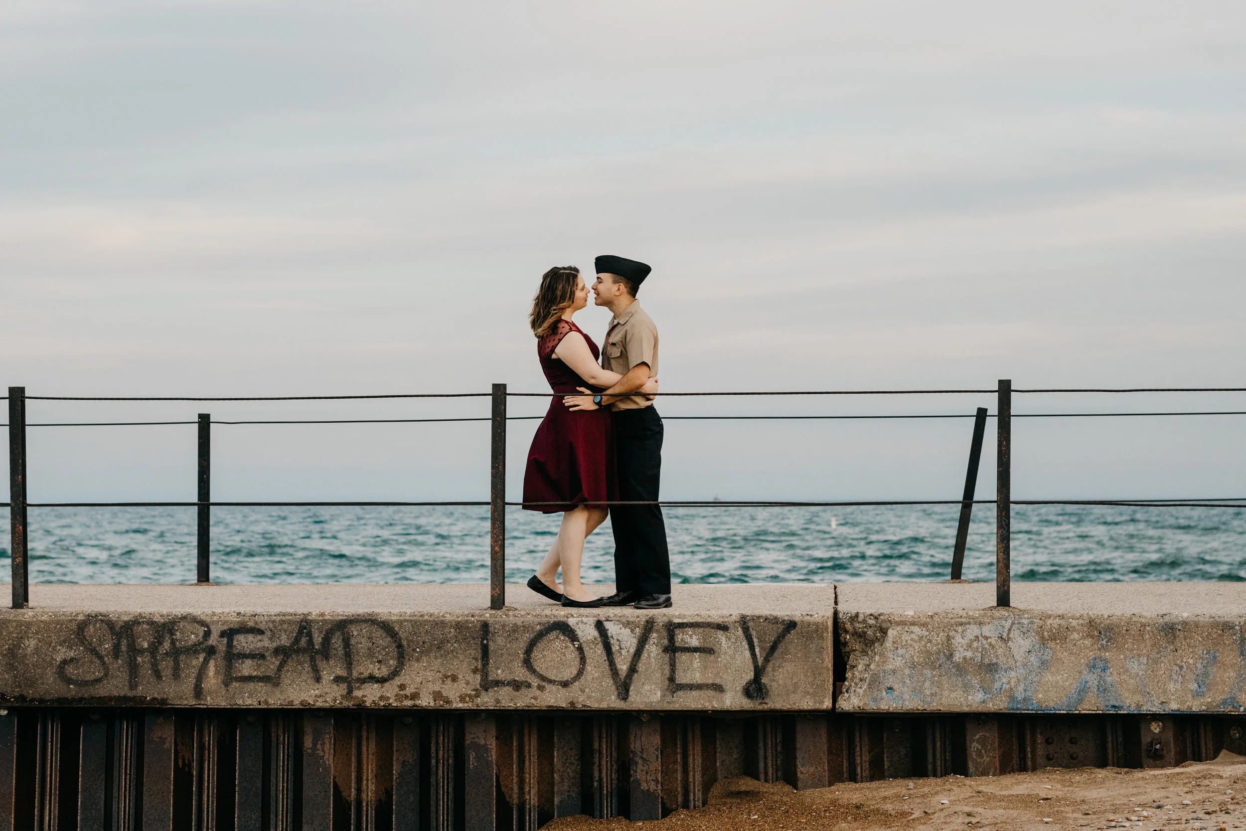engaged couple embracing at the Loyola Beach lighthouse