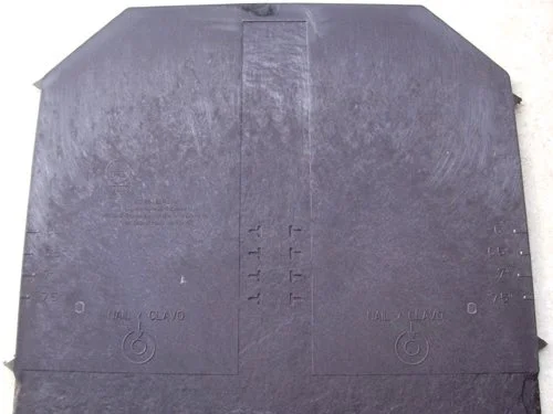 The upper surface of the head of the slate showing 2 circular nail hole positions and the choice of 4 gauge positions that may be adjusted to suit roof pitch.