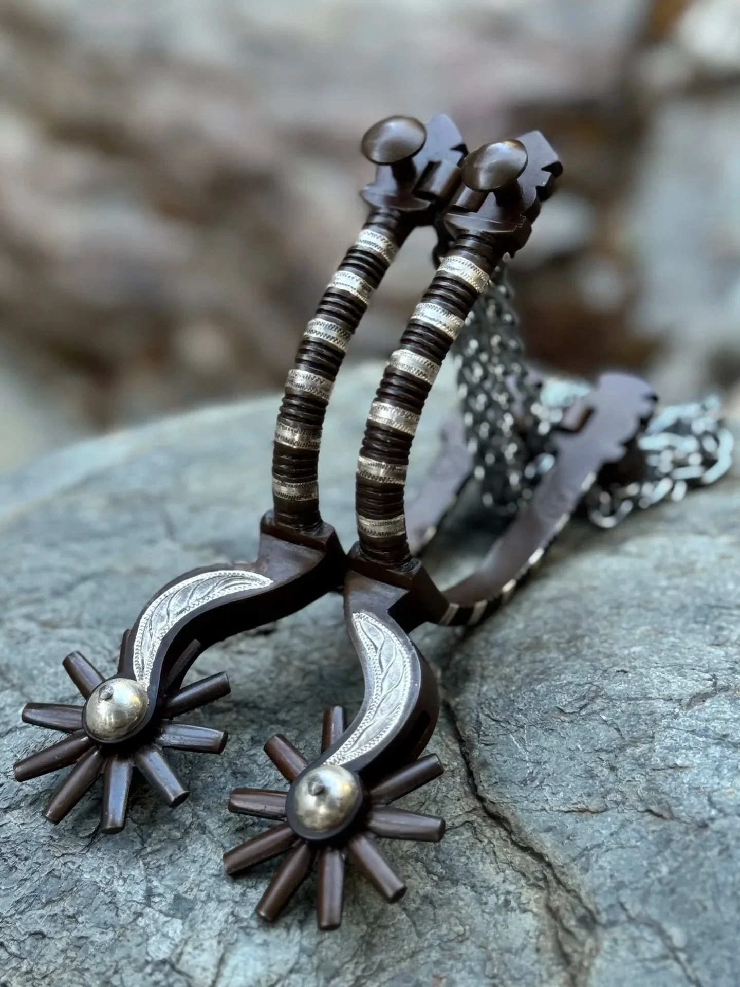 A set of Early California-style spurs for @baileyhrobinson .  These spurs feature double mounted sterling silver inlay and filed chased iron.  They have fixed buttons and vaquero heel chains.  The shanks are made in the shape of a crescent moon, one 