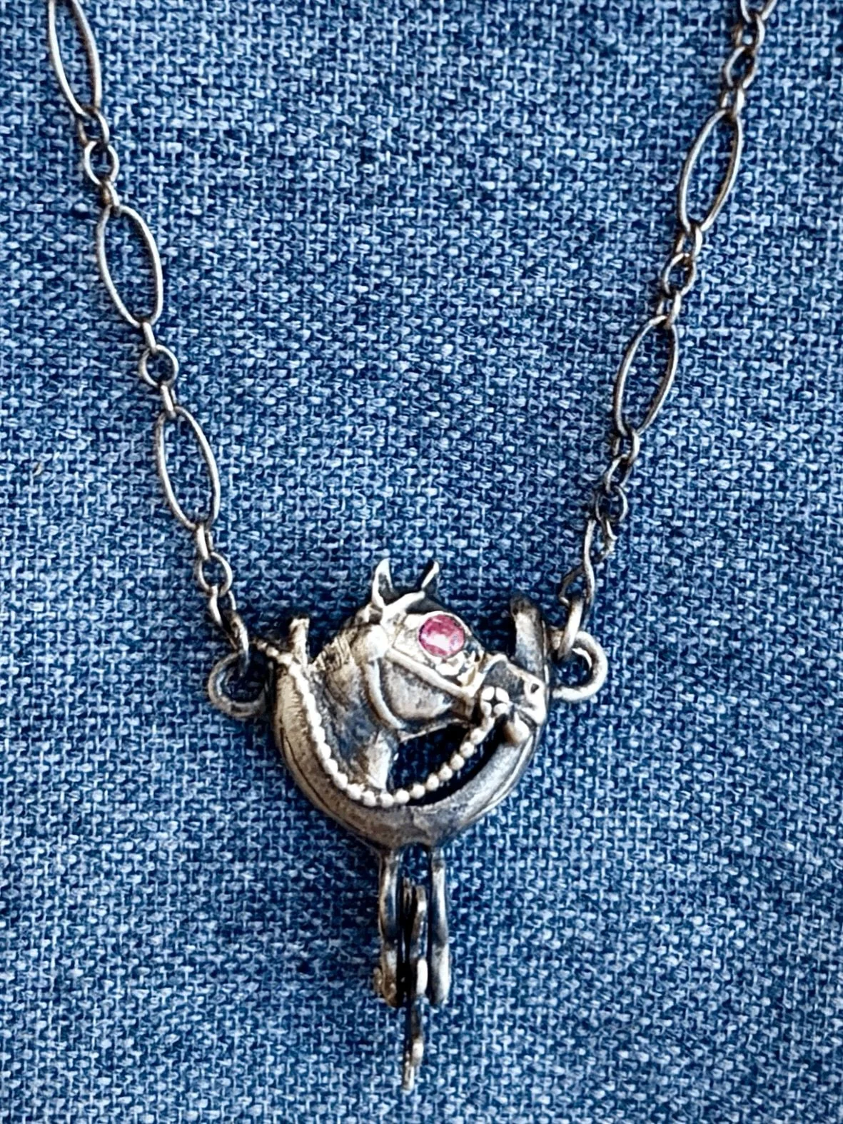 Antique Sterling Silver Western Spur and Horse Pendant with Ruby Eyes
Available here: https://theoldspanishtrading.com/silver-buckles-and-conchos/antique-sterling-silver-western-spur-and-horse-pendant-with-ruby-eyes 

Antique Sterling Silver Western 