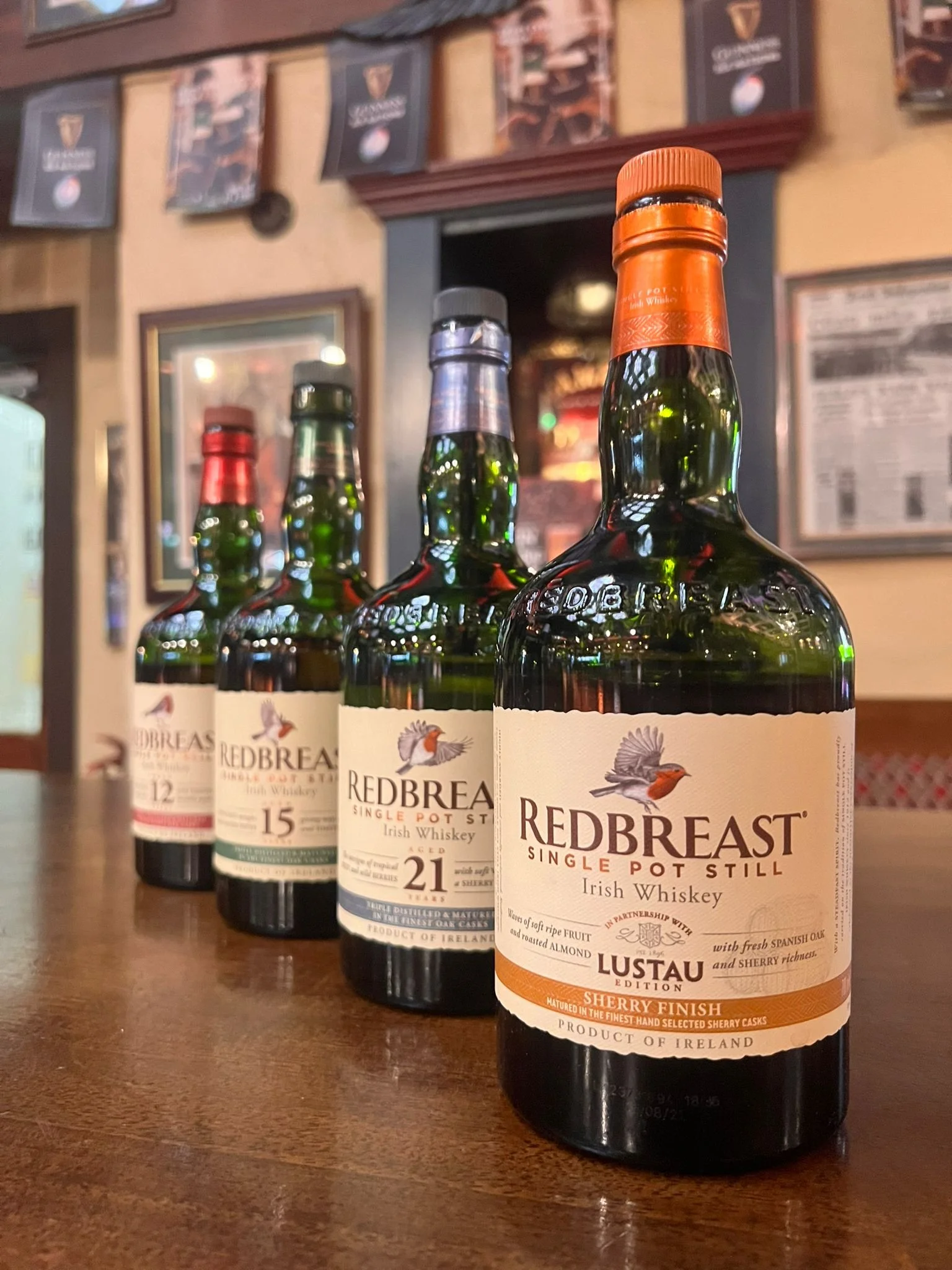 Four Rebreast Single Pot Still Irish Whiskey bottles lined up on a table.