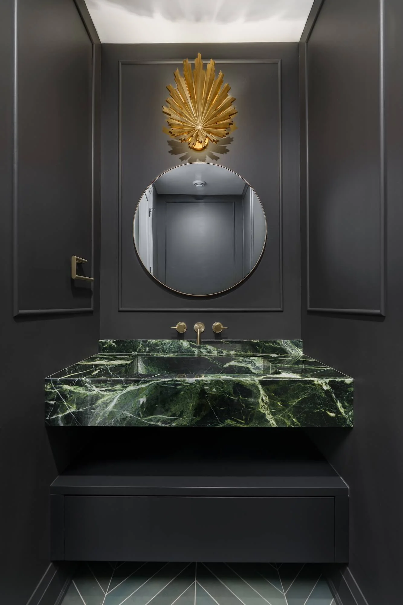 Moody Ottawa powder room with green marble vanity and brass light, by Marina Medina