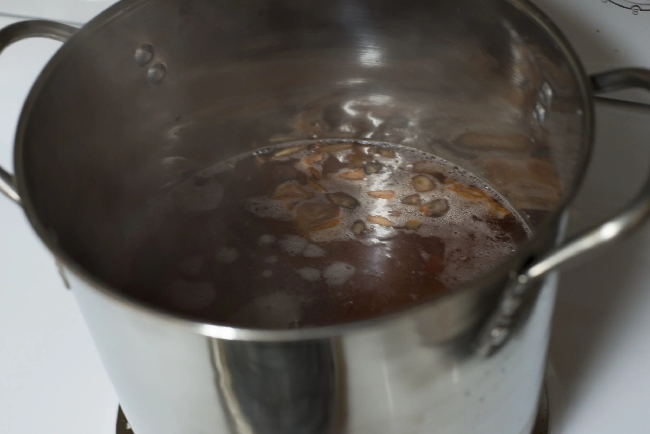 The avocado pit dye, just started simmering-- colored the water quickly!