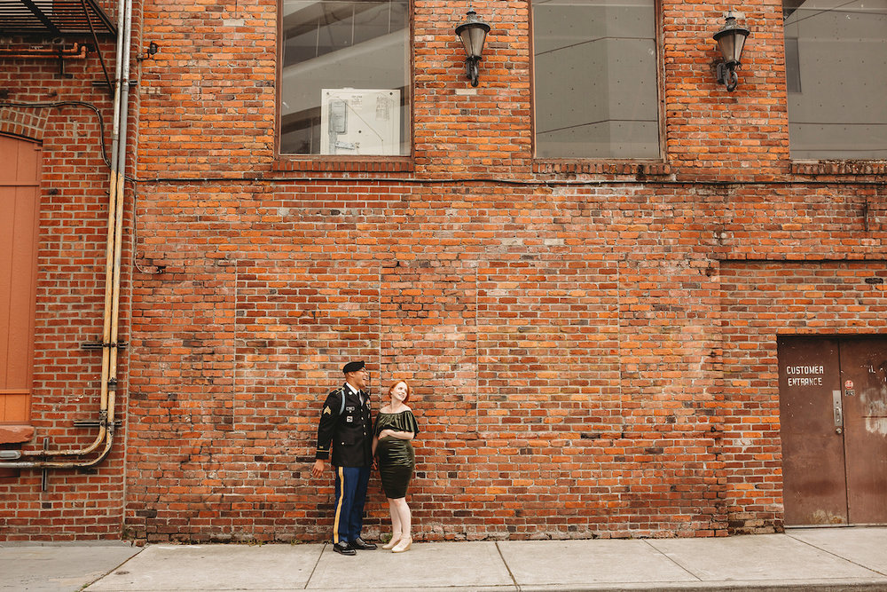 Newlywed couple with brick wall backdrop