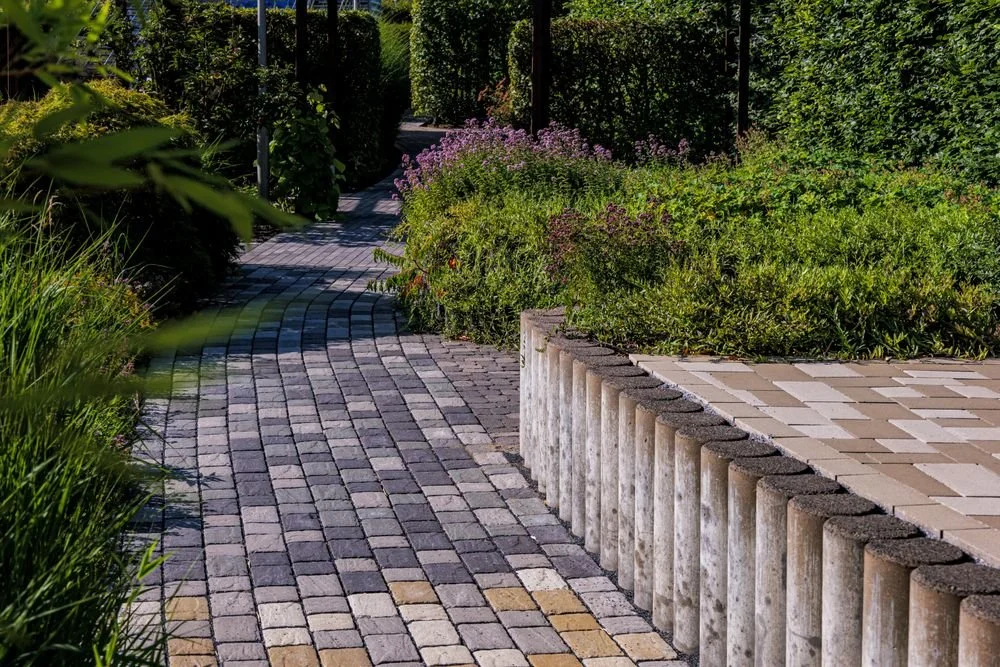 Curved paver walkway through a landscaped garden
