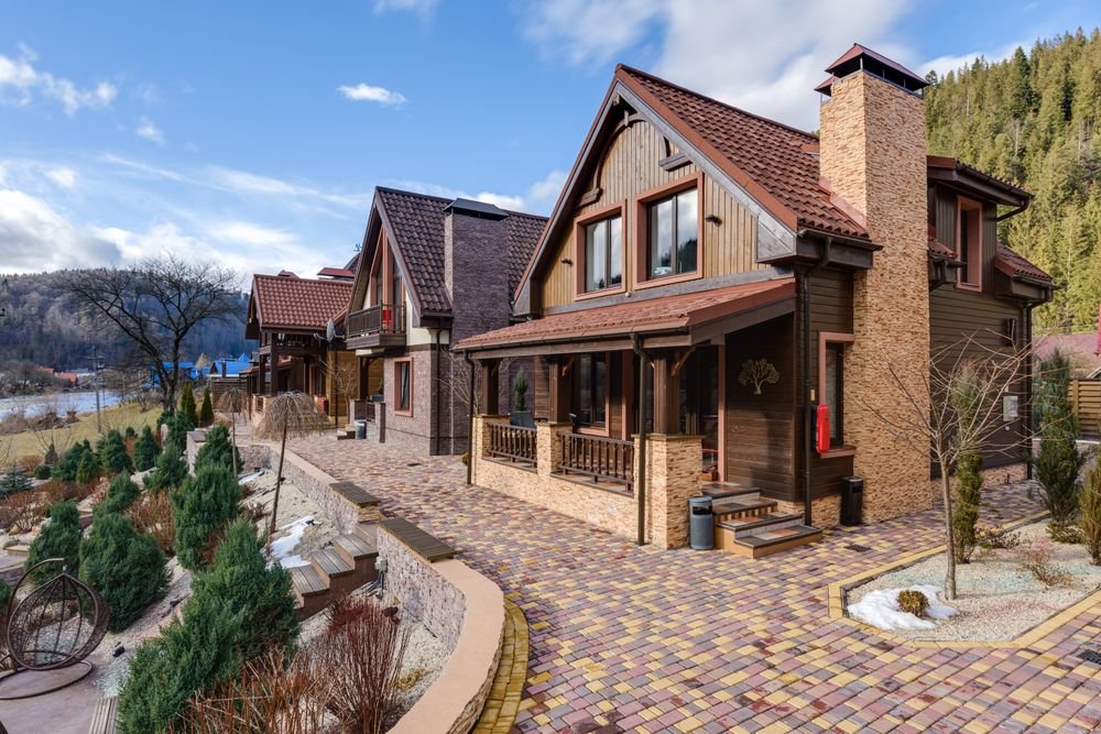Brick paver driveway surrounding a rustic home