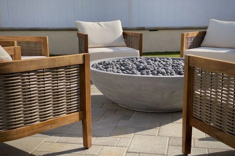 A cozy patio featuring a fire pit surrounded by comfortable chairs
