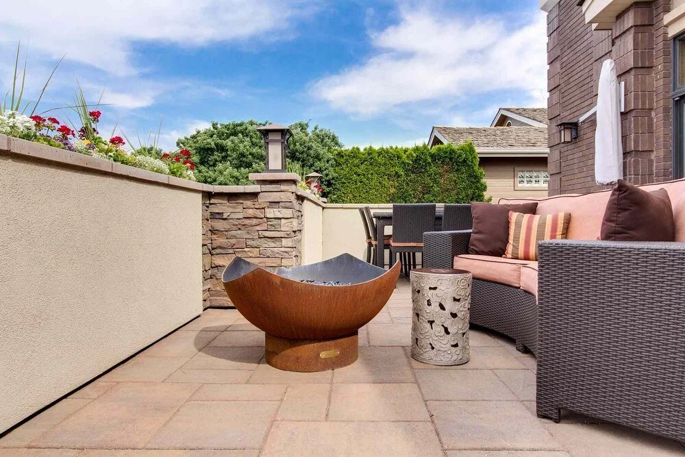 Modern backyard patio with metal fire pit and seating