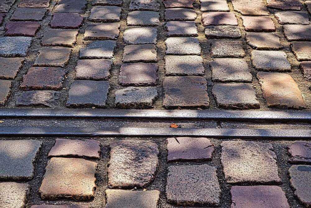 A brick walkway intersected by railroad tracks