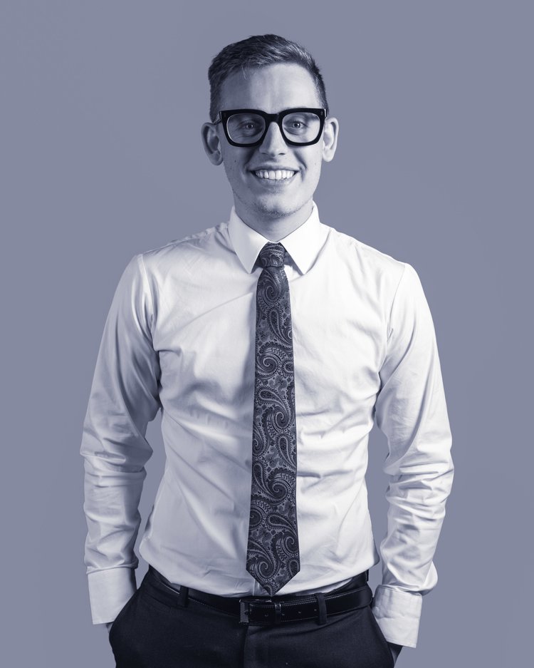 Black-and-white portrait of an Imagine Estate Agency team member wearing glasses, a white shirt and tie