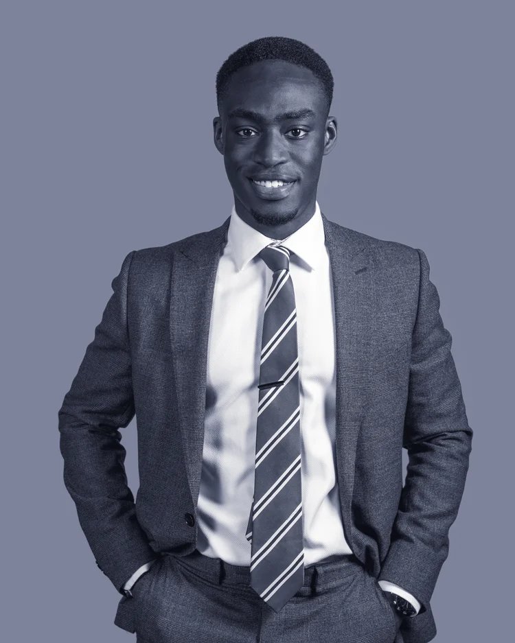 Black-and-white portrait of an Imagine Estate Agency team member in a dark suit and striped tie