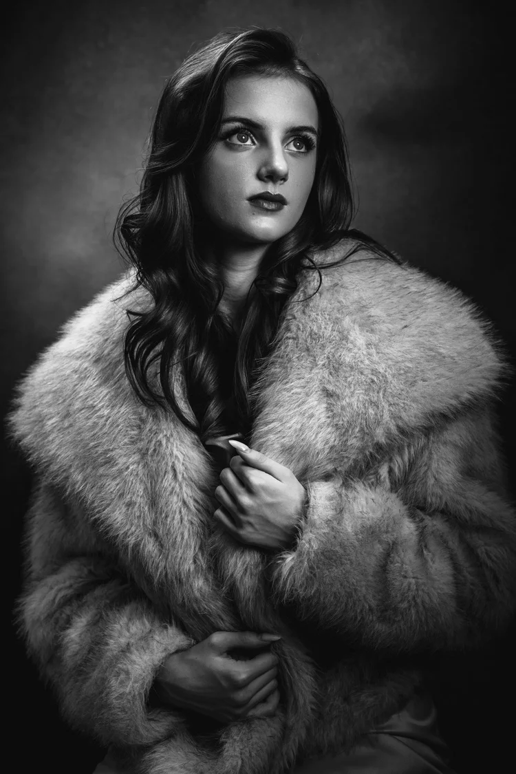 Black-and-white Hollywood-style portrait of Annabel in a fur-textured wrap, looking to the side.