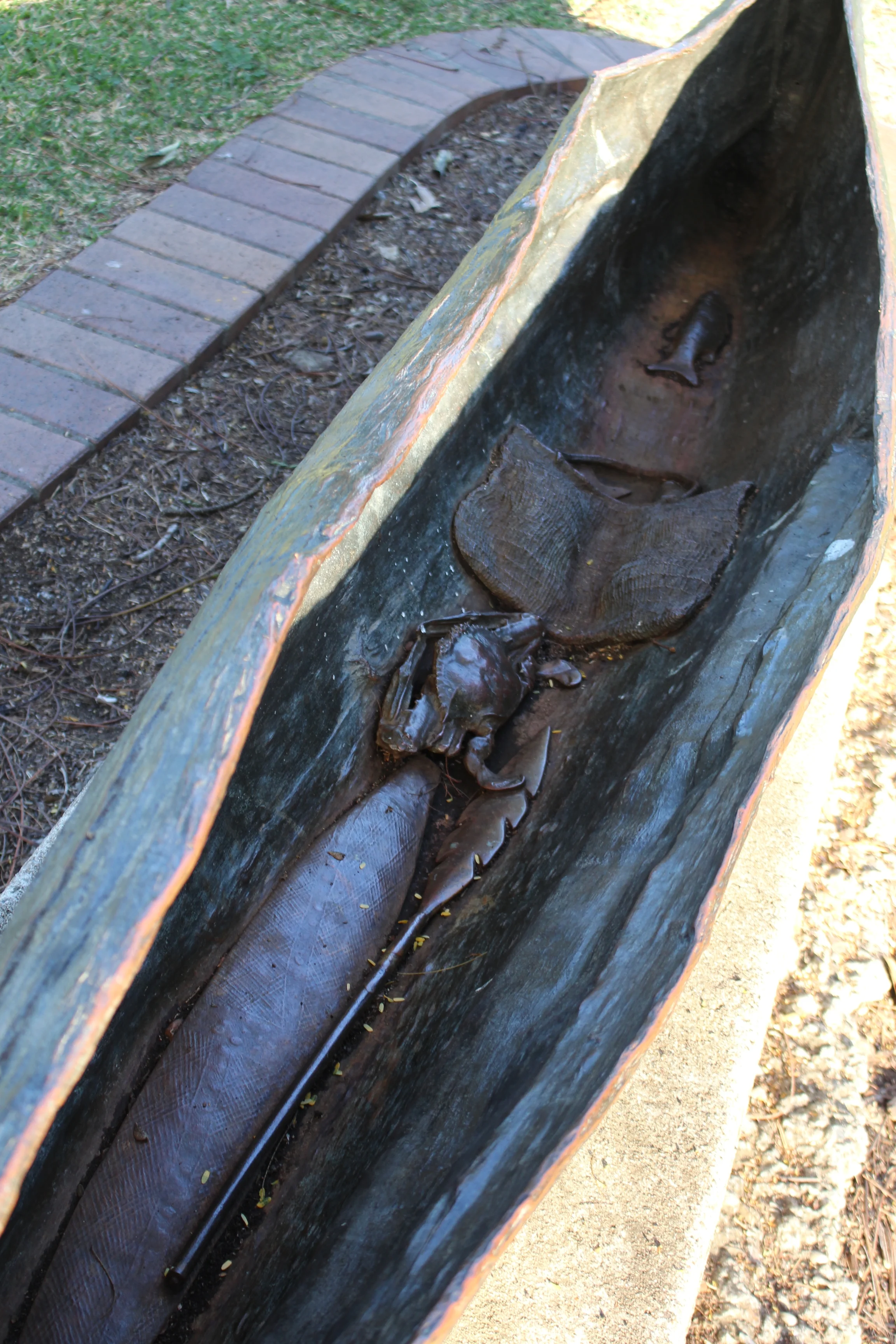 A spear, a dilly-bag, a crab and a fish.