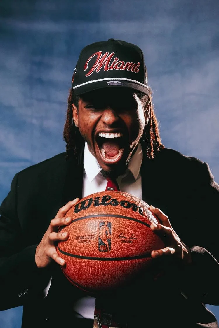 Model in a black suit and Miami cap laughs while holding a basketball in Draft Day. Photography by Yonathan Mesfun.