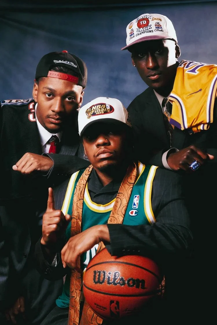 Three models combine suits, basketball jerseys and caps in a Draft Day studio portrait. Photography by Yonathan Mesfun.