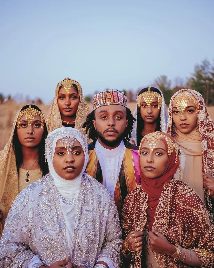 A group in embroidered garments and beaded headpieces gathers outdoors in A Collected Culture Pt.1. Photography by Yonathan Mesfun.