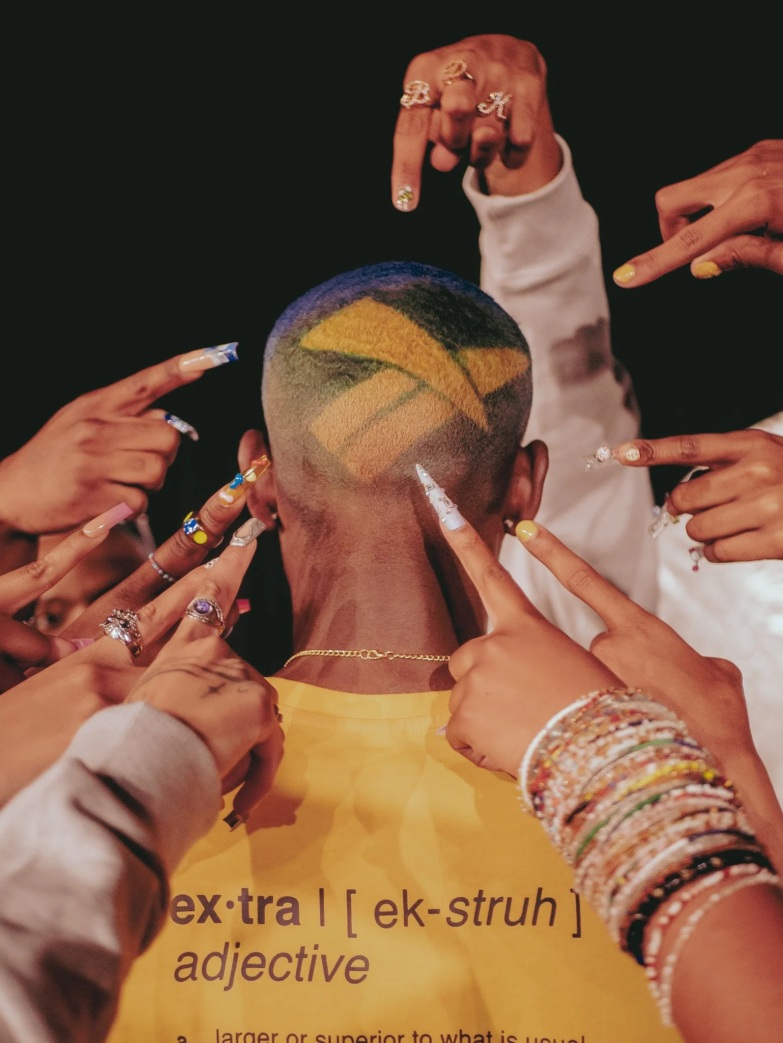 Hands with decorated nails surrounding a basketball design in a model’s cropped hair for Reebok. Photography by Yonathan Mesfun.