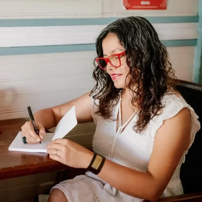 Marcela Corral escribiendo, facilitadora del taller Con Todo y Miedo