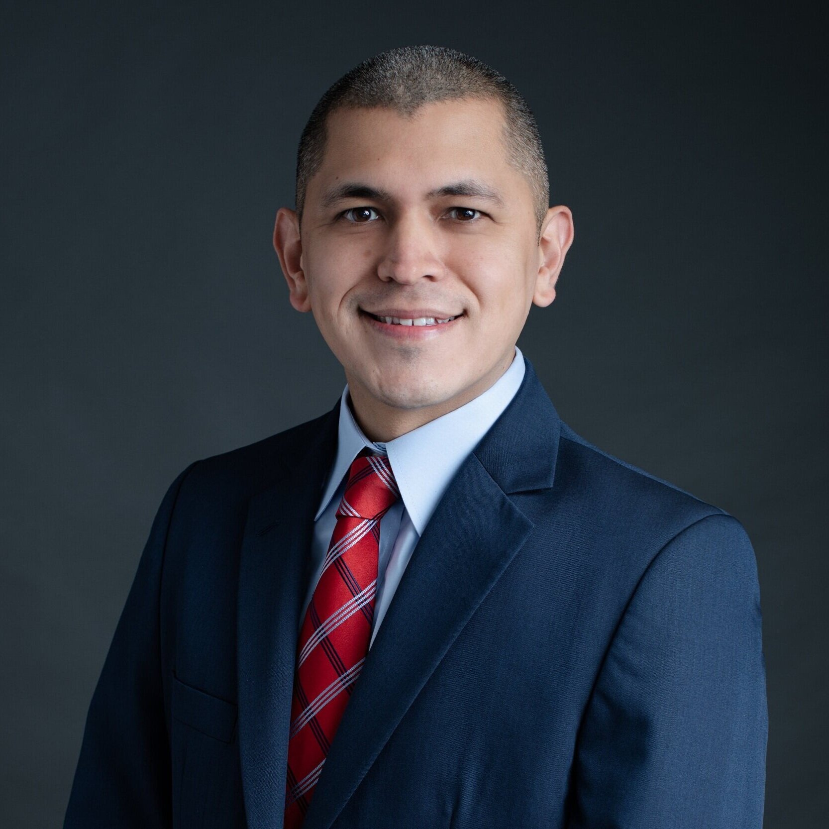 headshot of man in business suit grey background
