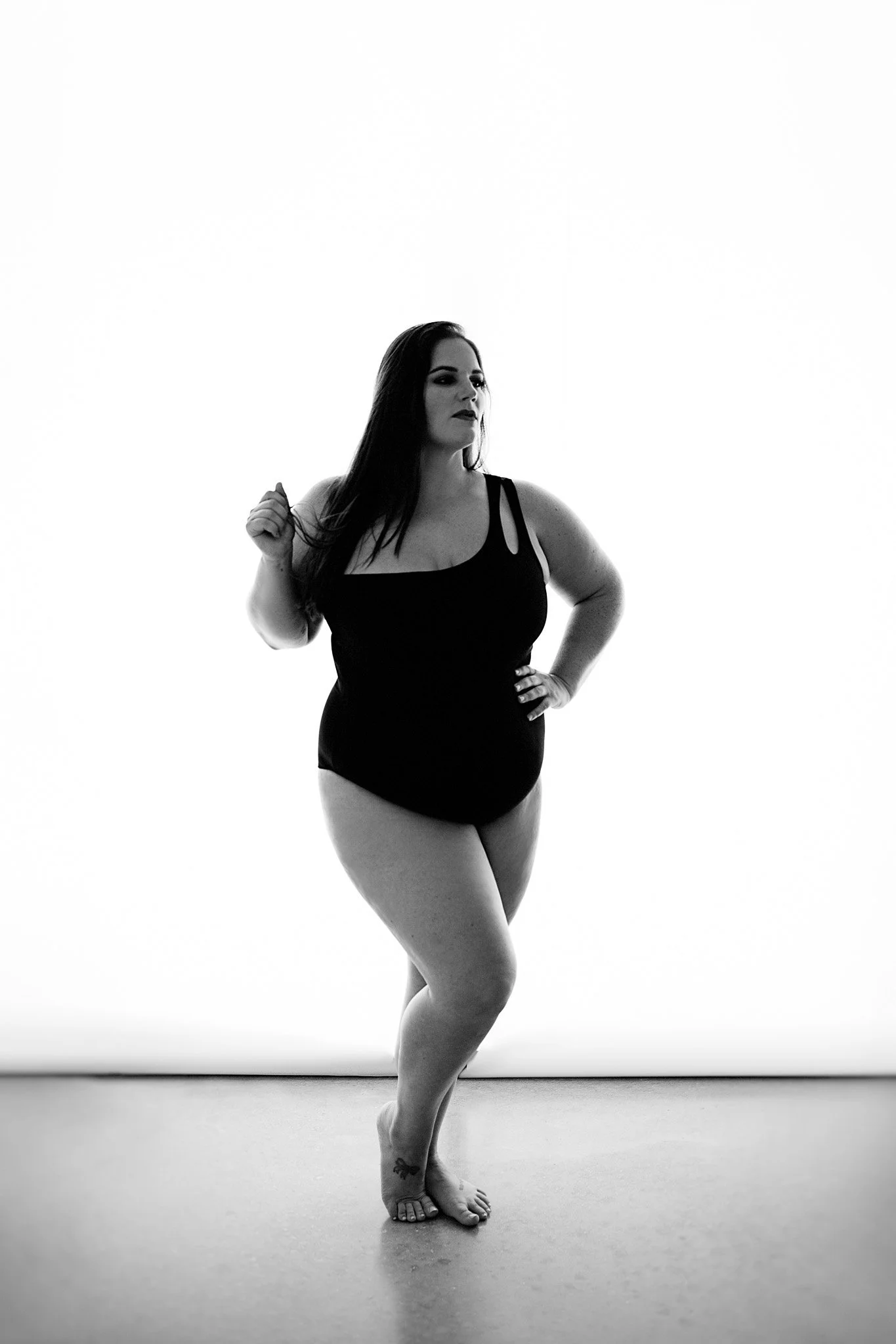 black and white plus size curvy boudoir portrait woman wearing bodysuit in studio / Photo by Erin Valkner Photography of New Braunfels, Texas. See more at www.erinvalknerphotography.com/blog