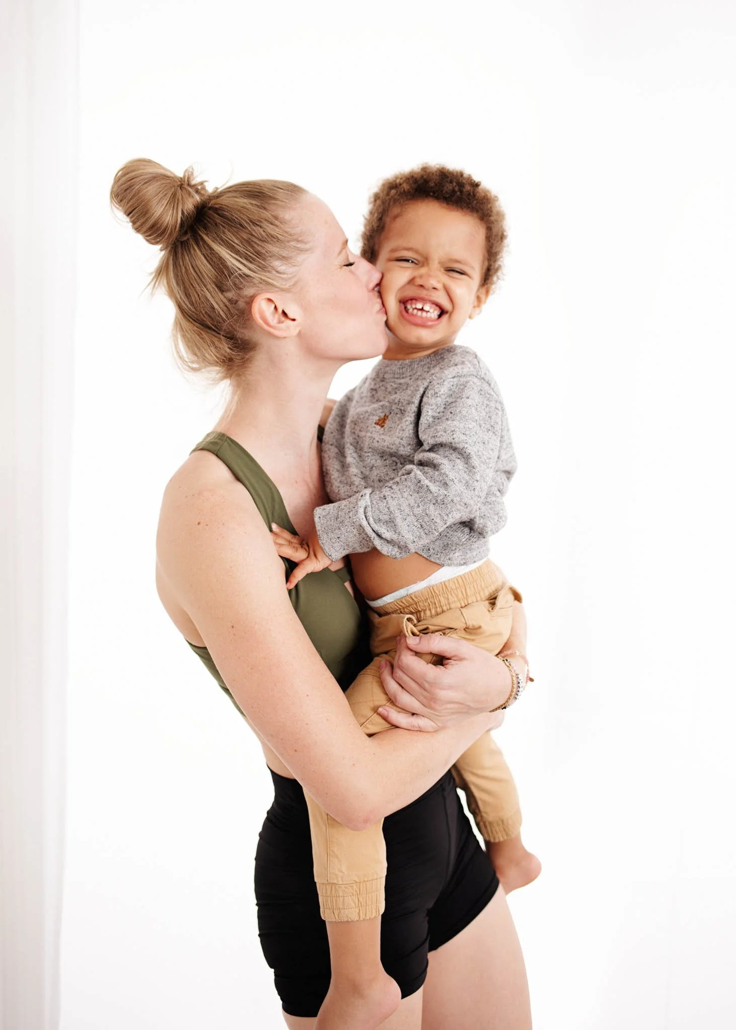 mom holding smiling son in studio by erin valkner photography in new braunfels texas