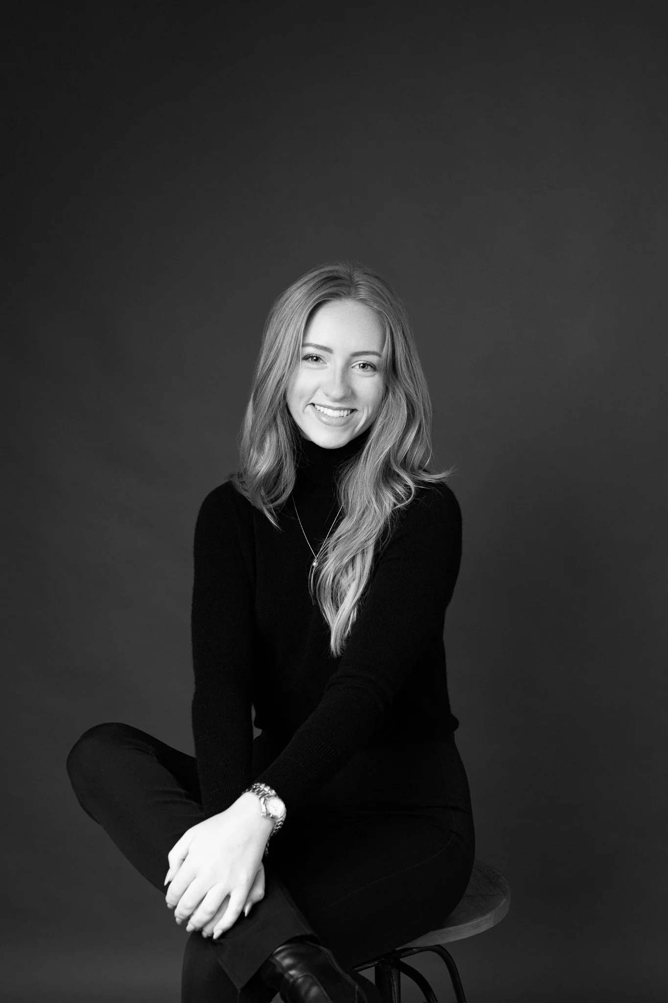 black and white portrait of smiling woman sitting on stool wearing black turtleneck / Portrait session in New Braunfels Texas studio | As I Am Sessions by Erin Valkner Photography