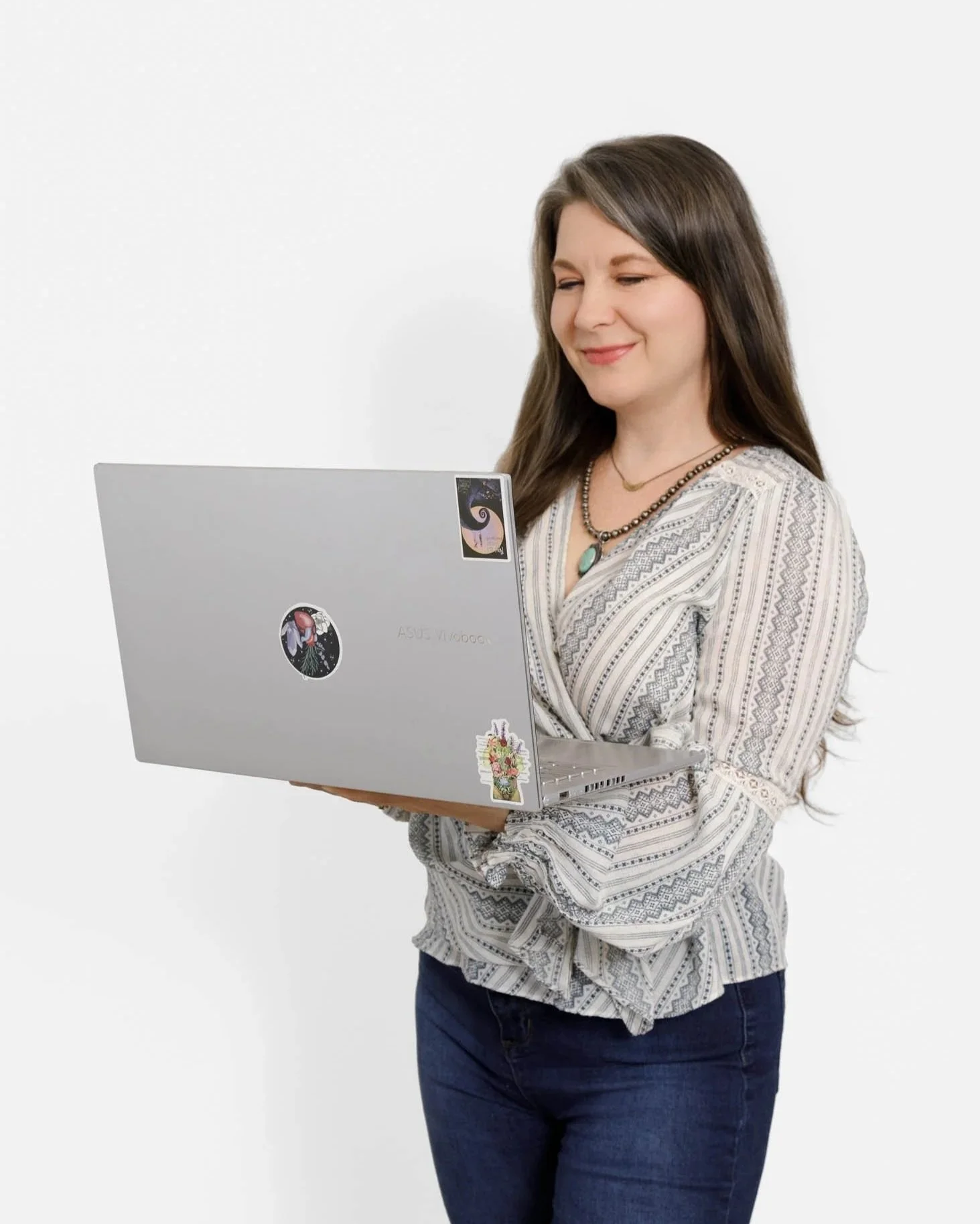 branding photo of woman standing holding and looking at open laptop on white backdrop in studio / Photo by Erin Valkner Photography of New Braunfels, Texas. See more at www.erinvalknerphotography.com/blog