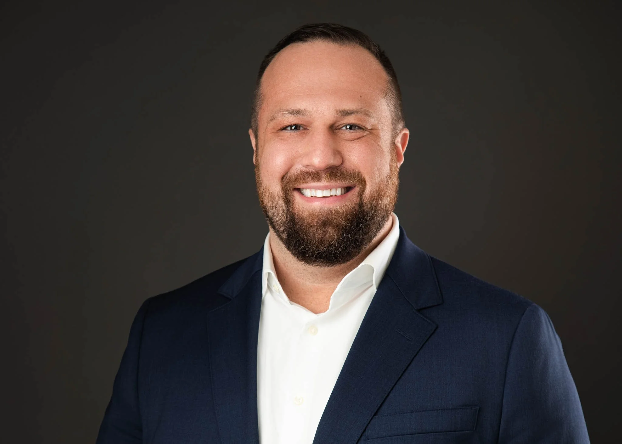professional headshot of man in blue suit dark background in New Braunfels studio   / Photo by Erin Valkner Photography of New Braunfels, Texas. See more at www.erinvalknerphotography.com/blog