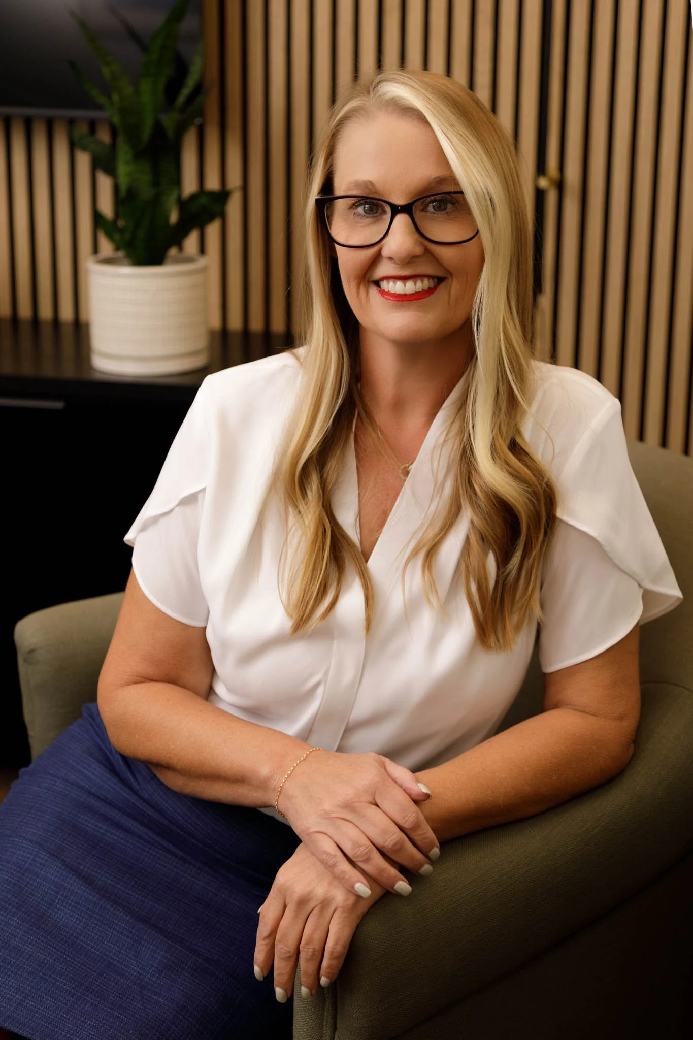 branding photo woman with blond long hair and glasses sitting pose in armchair in office / Photo by Erin Valkner Photography of New Braunfels, Texas. See more at www.erinvalknerphotography.com/blog