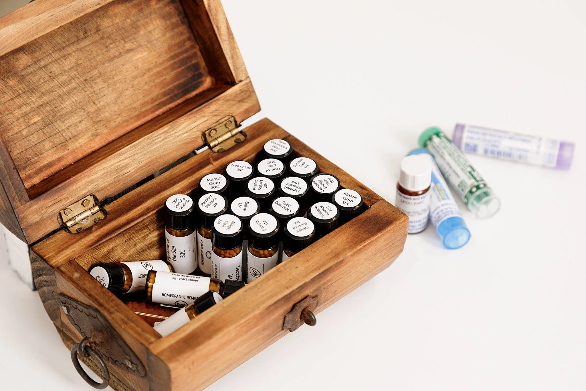 product photo of homeopathic vials in wooden box on white table / Photo by Erin Valkner Photography of New Braunfels, Texas. See more at www.erinvalknerphotography.com/blog
