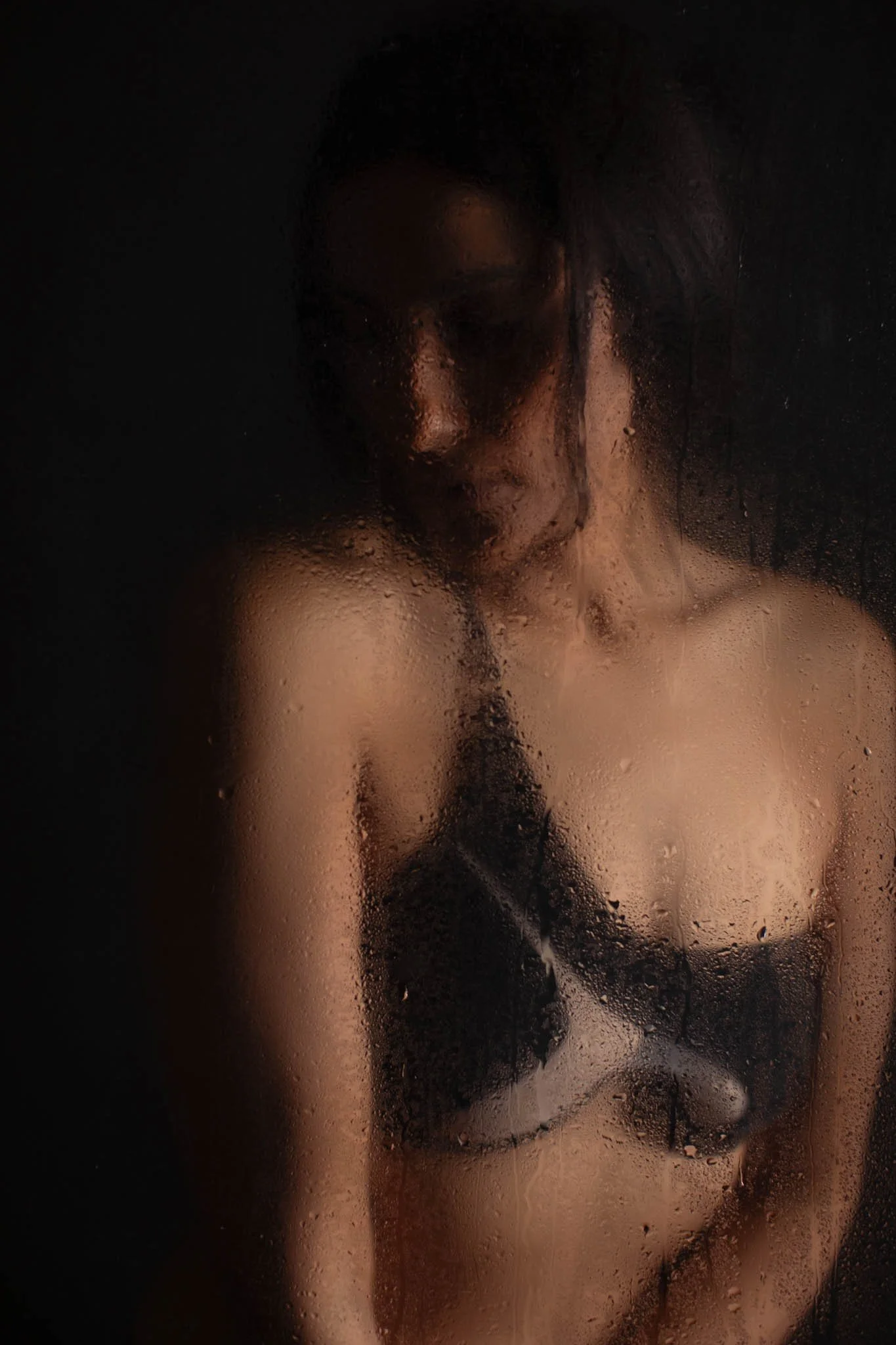 faux shower look boudoir photo of woman looking away from camera dark backdrop in studio  / Photo by Erin Valkner Photography of New Braunfels, Texas. See more at www.erinvalknerphotography.com/blog