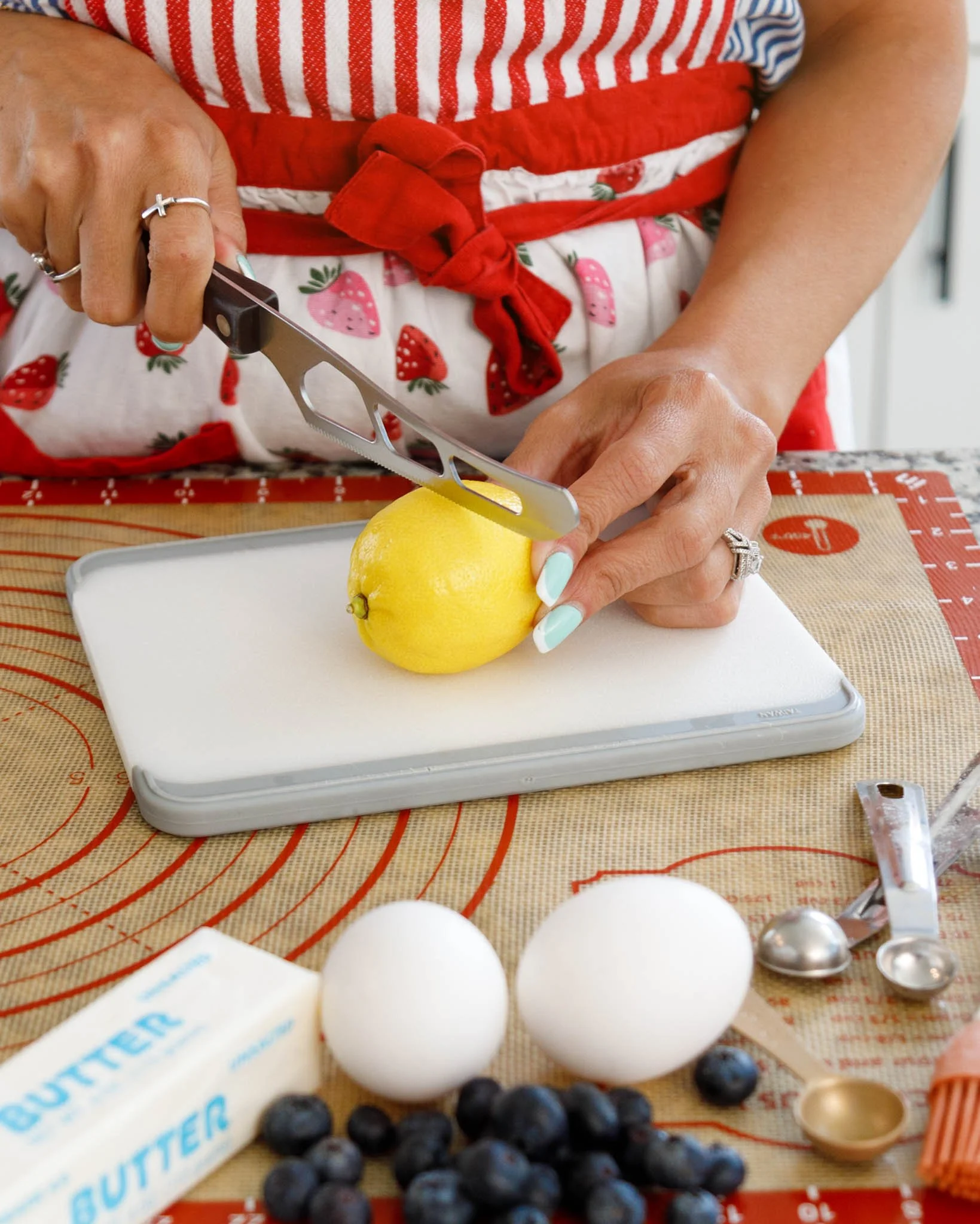 editorial branding photo of woman cutting lemon on cutting board next to baking ingredients and measuring spoons / Photo by Erin Valkner Photography of New Braunfels, Texas. See more at www.erinvalknerphotography.com/blog