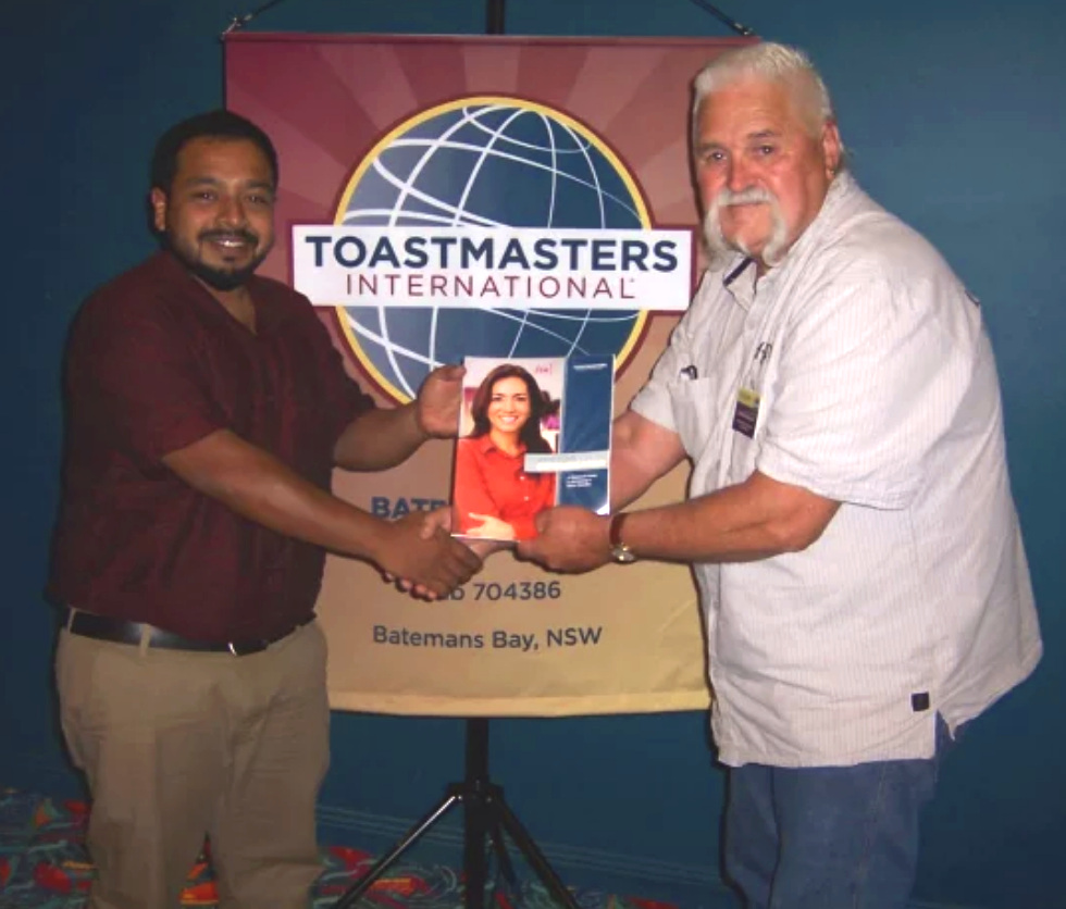 Moosa is presented with his first Toastmasters manual by President Noal Annabel